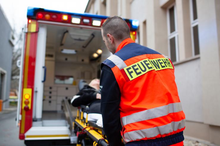 Notfallsanitäter schiebt Patient in den Rettungswagen