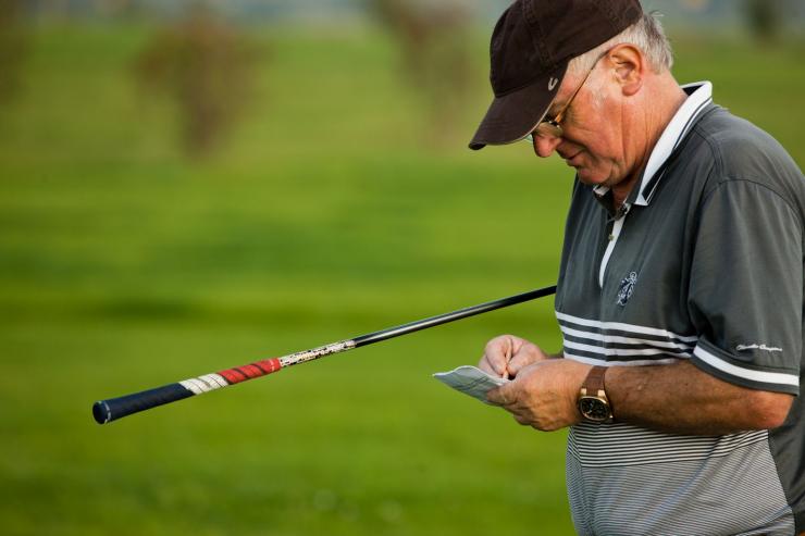 Mann notiert Spielstand beim Golf