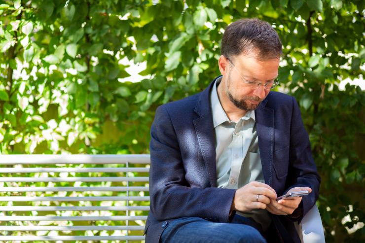 Oberbürgermeister arbeitet mit dem Smartphone im Park 