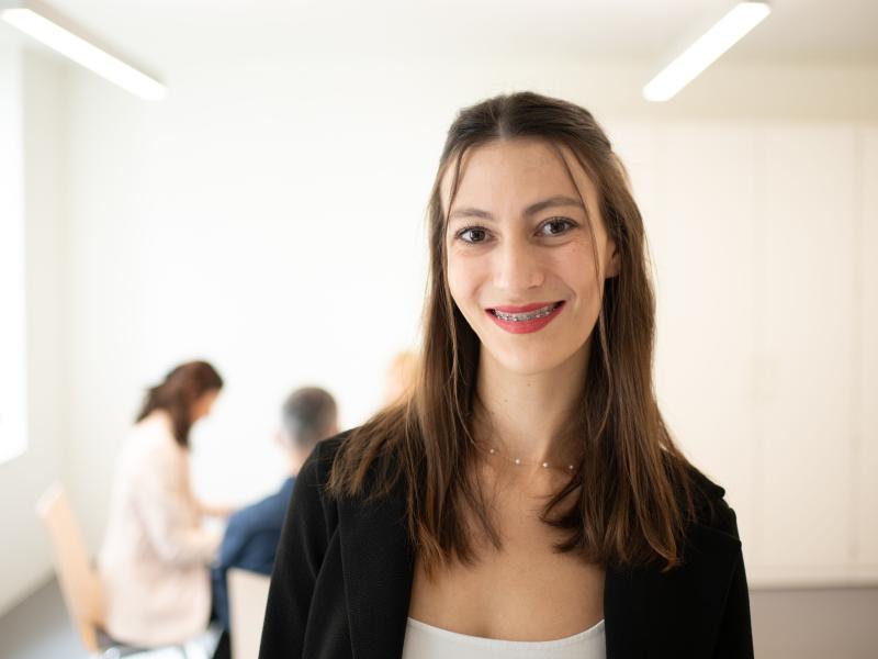 Eine Frau mit dunklem Haar lächelt in die Kamera