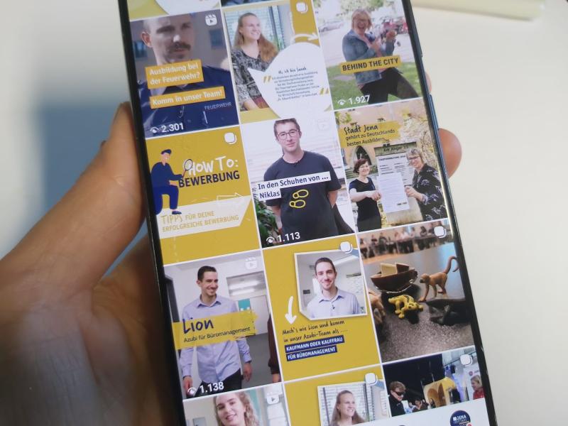 Hand mit Mobiltelefon, auf dem Screen ist der Instagram-Account der Stadt Jena zu sehen
