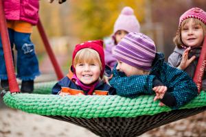 Mehrere Kinder auf einer Korbschaukel