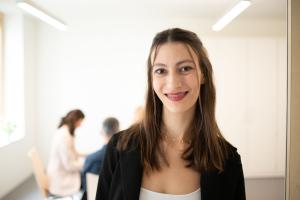 Eine Frau mit dunklem Haar lächelt in die Kamera