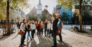 Menschengruppe auf dem Marktplatz, im Hintergrund das Historische Rathaus