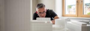 Mann schaut sich ein Modell an - Stadtplanung